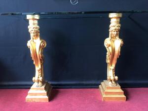 Console avec deux colonnes caryatides en platre dorée à la feuille d’or début 20 eme s avec plateau de verre fumé bizauté H 90cm plateau L120cm x 45cm